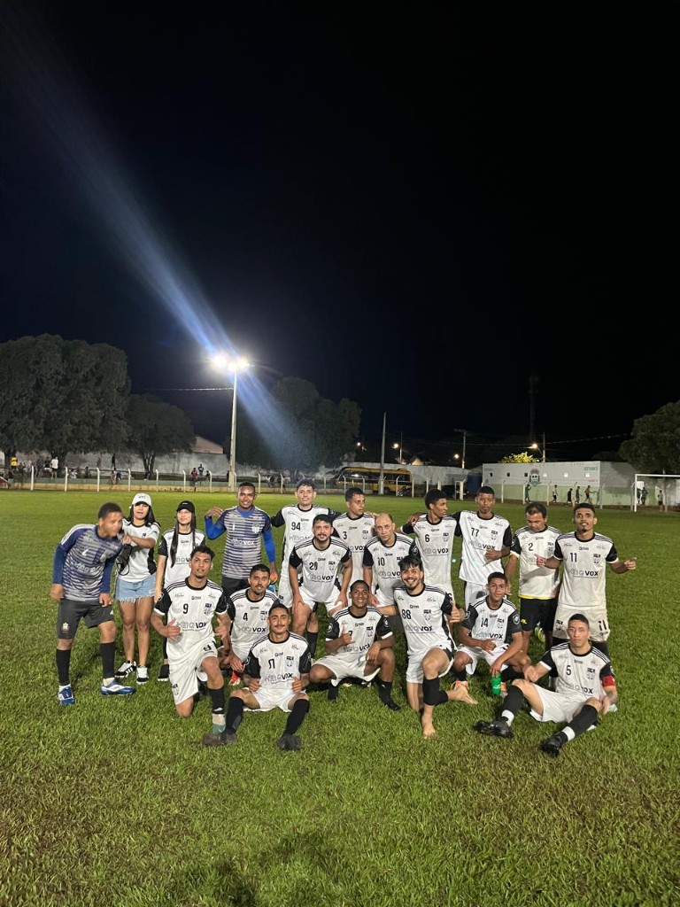 Equipa em foto oficial no relvado à noite com holofotes