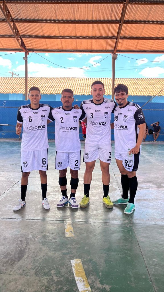 Quatro jogadores em quadra coberta com equipamentos da equipa